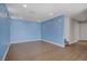Spacious living room featuring blue walls, recessed lighting, and attractive wood-look floors at 9932 Keephills St, Las Vegas, NV 89183