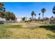 View of neighborhood landscape, green grass, palm trees and blue sky at 9932 Keephills St, Las Vegas, NV 89183