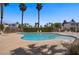 Community swimming pool with palm trees, lounge chairs, and safety fence at 9932 Keephills St, Las Vegas, NV 89183