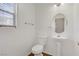 Downstairs powder room with a pedestal sink and neutral decor at 9932 Keephills St, Las Vegas, NV 89183