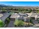 An elevated view of a modern home with paver driveway, desert landscaping, and mountain views at 10004 Terrastone Dr, Las Vegas, NV 89148
