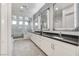 Bright bathroom featuring dual sinks, decorative mirrors, and a glass-enclosed shower and tub at 10004 Terrastone Dr, Las Vegas, NV 89148