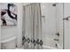 A close-up of the tub/shower combo with white tiling, a shower curtain and a toilet at 10004 Terrastone Dr, Las Vegas, NV 89148