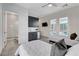 View of a bedroom with ensuite bathroom and a wet bar with stainless steel mini fridge at 10004 Terrastone Dr, Las Vegas, NV 89148