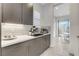 Modern coffee bar area featuring gray cabinets, white backsplash, and stainless steel appliances at 10004 Terrastone Dr, Las Vegas, NV 89148