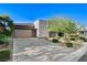 Modern home featuring a gray stone and stucco exterior, a paver driveway, and lush landscaping at 10004 Terrastone Dr, Las Vegas, NV 89148