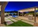 Outdoor kitchen and pool area with manicured lawn and privacy landscaping at 10004 Terrastone Dr, Las Vegas, NV 89148