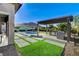 Stunning backyard showcasing a sparkling pool, outdoor kitchen, and meticulously designed landscaping against a backdrop of scenic mountains at 10004 Terrastone Dr, Las Vegas, NV 89148