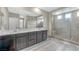 Sleek bathroom featuring double sinks, stone floors, and glass-enclosed shower at 10189 Magnolia Creek St, Las Vegas, NV 89141