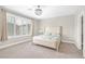 A bright bedroom has large windows and a ceiling fan with modern decor at 10189 Magnolia Creek St, Las Vegas, NV 89141