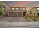 Inviting two-story home featuring a stone facade, three-car garage, balcony and landscaped front yard at 10189 Magnolia Creek St, Las Vegas, NV 89141