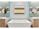 The white soaking tub with wooden cabinetry, decorative sconces, and framed window offers a serene escape at 103 Reflection Cove Dr, Henderson, NV 89011