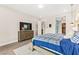Cozy bedroom features a blue-and-white bedspread, natural light, and a dresser with a television at 103 Reflection Cove Dr, Henderson, NV 89011