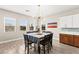 Bright dining room with a table set for eight, a chandelier, and three windows overlooking the neighborhood at 103 Reflection Cove Dr, Henderson, NV 89011