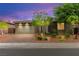 Charming home showcasing a modern garage door, stone accents, a manicured front yard, and tasteful landscaping at 103 Reflection Cove Dr, Henderson, NV 89011