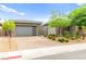 Modern home exterior boasts a stylish garage, stone detailing, neat landscaping, and a welcoming driveway at 103 Reflection Cove Dr, Henderson, NV 89011