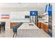 The kitchen features white and blue cabinets, stainless steel appliances, a mosaic backsplash and a large center island at 103 Reflection Cove Dr, Henderson, NV 89011
