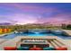 Stunning pool features a waterfall, spa, fire pit, lounge chairs, and mountain views for luxurious outdoor living at 103 Reflection Cove Dr, Henderson, NV 89011