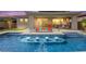 Backyard pool featuring in-pool lighting, a built-in fire pit, covered patio area, and ample seating at 103 Reflection Cove Dr, Henderson, NV 89011