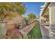 Backyard with artificial turf, terraced garden, and a covered patio area at 10611 Auburn Springs Ave, Las Vegas, NV 89166