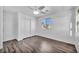 Bright bedroom with wood-look floors, ceiling fan, window views, and closet with sliding doors at 10611 Auburn Springs Ave, Las Vegas, NV 89166