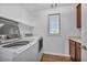 Laundry room featuring front load washer and dryer, wood-look floors, and storage cabinets at 10611 Auburn Springs Ave, Las Vegas, NV 89166