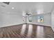 Spacious living room with hardwood floors, three windows, and a modern ceiling fan at 10611 Auburn Springs Ave, Las Vegas, NV 89166