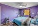 A purple bedroom with wood floors, a ceiling fan, and natural light at 11117 Romola St, Las Vegas, NV 89141