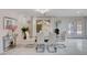 Bright dining area with a glass table, white chairs, and stylish decor, complemented by natural light and white tile floors at 11117 Romola St, Las Vegas, NV 89141