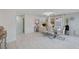 Bright dining area with a glass table, white chairs, and stylish decor, complemented by natural light and white tile floors at 11117 Romola St, Las Vegas, NV 89141