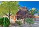 A cozy home with festive decorations sits amid well-maintained landscaping and mature trees on a sunny day at 11117 Romola St, Las Vegas, NV 89141