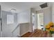 Bright hallway featuring a modern chandelier, hardwood floors, and access to bedrooms and a full bathroom at 11117 Romola St, Las Vegas, NV 89141