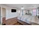 Large main bedroom with a mounted TV, modern chandelier, hardwood floors, and an en-suite bathroom at 11117 Romola St, Las Vegas, NV 89141