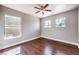 Cozy bedroom featuring hardwood floors, a ceiling fan, and multiple windows providing natural light at 1112 Caraway Ln, Las Vegas, NV 89144