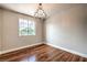Bright bedroom features gleaming hardwood floors, a stylish chandelier, and a window view at 1112 Caraway Ln, Las Vegas, NV 89144