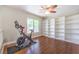 Spacious bonus room with hardwood floors, built-in shelving and a ceiling fan with large window overlooking the back yard at 1112 Caraway Ln, Las Vegas, NV 89144