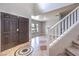 Welcoming foyer featuring a staircase, tile flooring with a decorative medallion, and a double door entry, creating a grand entrance at 1112 Caraway Ln, Las Vegas, NV 89144
