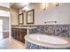 Luxurious main bathroom featuring dual sinks, an oval soaking tub, and updated vanity with decorative mirror at 1112 Caraway Ln, Las Vegas, NV 89144