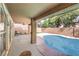 Covered patio area overlooking a sparkling pool and mature trees is perfect for outdoor living at 1112 Caraway Ln, Las Vegas, NV 89144