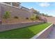 Landscaped backyard with artificial turf and retaining walls at 127 Medianoche St, Las Vegas, NV 89138