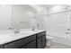 Bathroom featuring double sinks and a tub/shower combo with white tile surround at 127 Medianoche St, Las Vegas, NV 89138
