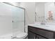Bright bathroom featuring a glass shower enclosure, white toilet and dark vanity with white sink at 127 Medianoche St, Las Vegas, NV 89138