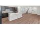 Open-concept kitchen with island, stainless steel appliances, tile backsplash, and staircase to upper level at 127 Medianoche St, Las Vegas, NV 89138