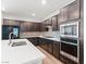 Modern kitchen featuring stainless steel appliances, a tile backsplash, and dark wood cabinetry at 127 Medianoche St, Las Vegas, NV 89138