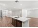 Open kitchen view with island, stainless sink, and wood-look tile flooring throughout the living space at 127 Medianoche St, Las Vegas, NV 89138