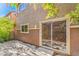 Private backyard with a covered patio area, mature shrubs, and sliding glass door entrance at 137 Desert Pond Ave, Henderson, NV 89002