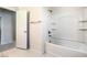 Clean bathroom showcasing a bathtub with a shower, white tiling, and convenient built-in shelving at 137 Desert Pond Ave, Henderson, NV 89002