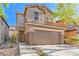 Two-story home showcasing well-maintained landscaping, a two-car garage, and a welcoming front entrance at 137 Desert Pond Ave, Henderson, NV 89002