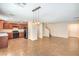 Open living and kitchen area with dark appliances, tile floor and staircase at 137 Desert Pond Ave, Henderson, NV 89002