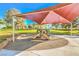 Community playground with slides and climbing structures under a shade cover, surrounded by landscaped greenery at 137 Desert Pond Ave, Henderson, NV 89002